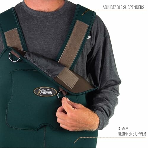 Person wearing neoprene waders with adjustable suspenders.